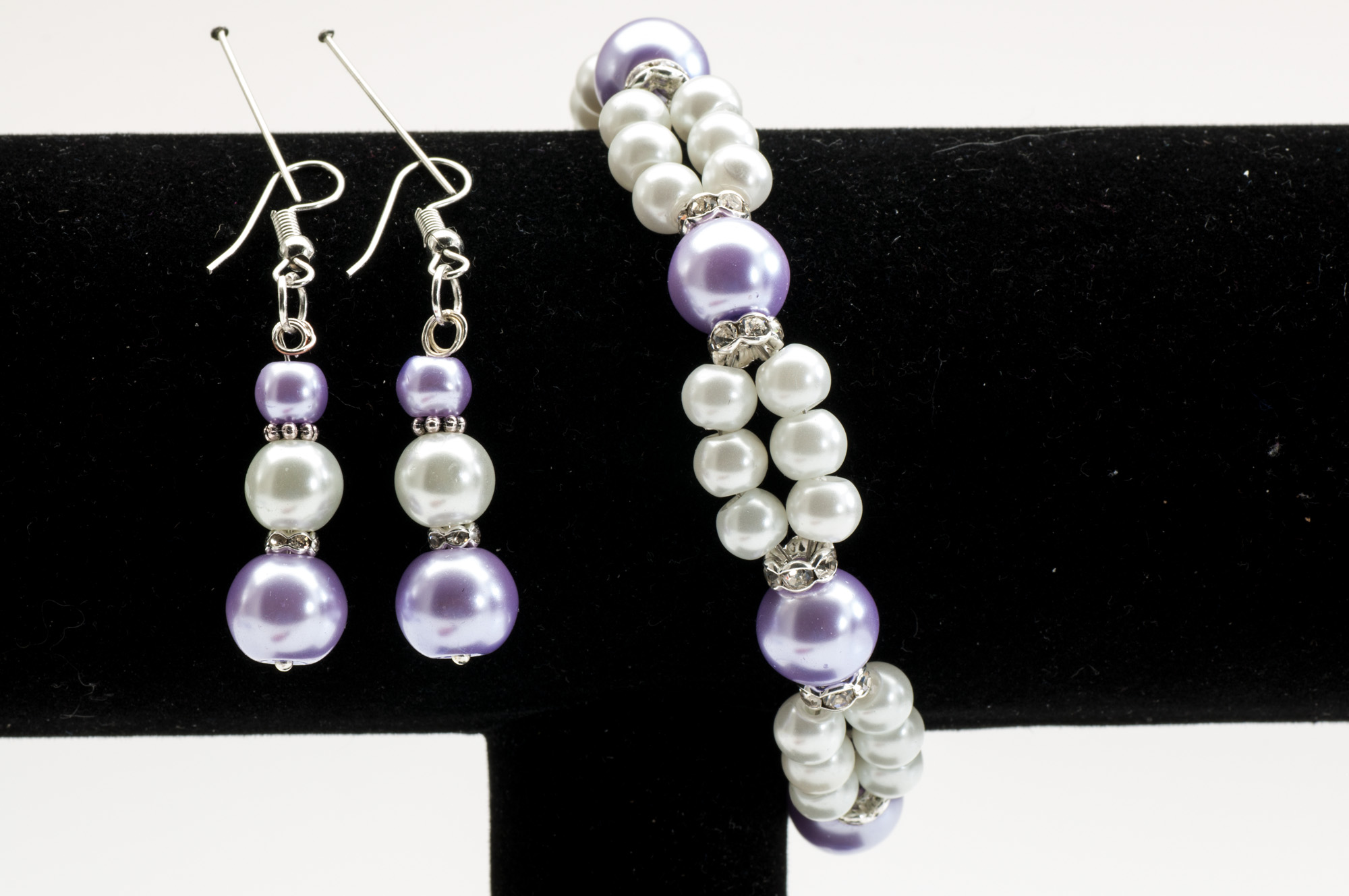 Set med lavendellila och pärlvita vaxade glaspärlor: hängörhängen på fiskekrok och dubbelt armband med mellandelar i silverfärg.