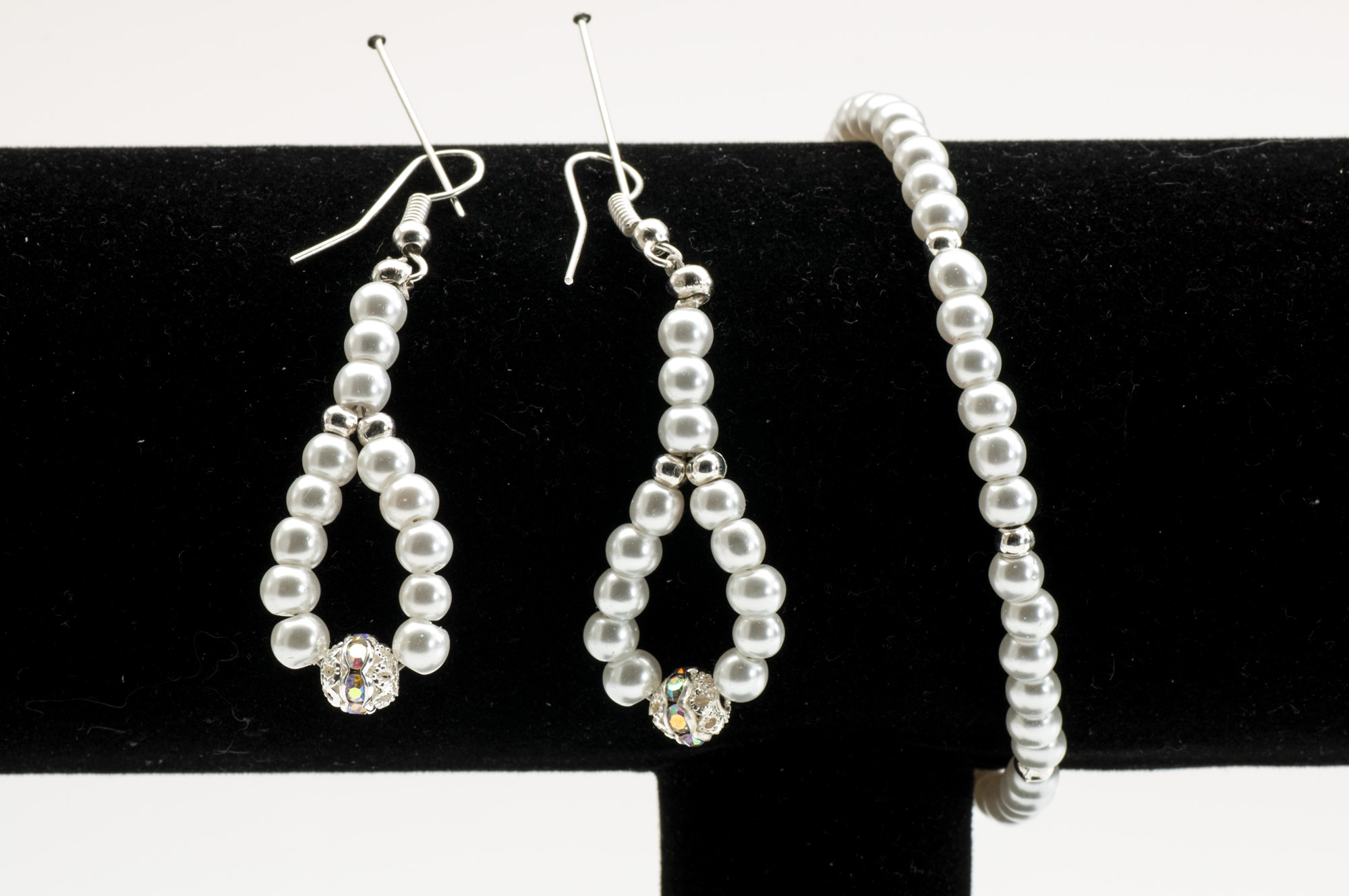 Klassiska pärlörhängen i droppform med strasskula i botten och matchande smalt armband i pärlvita glaspärlor.